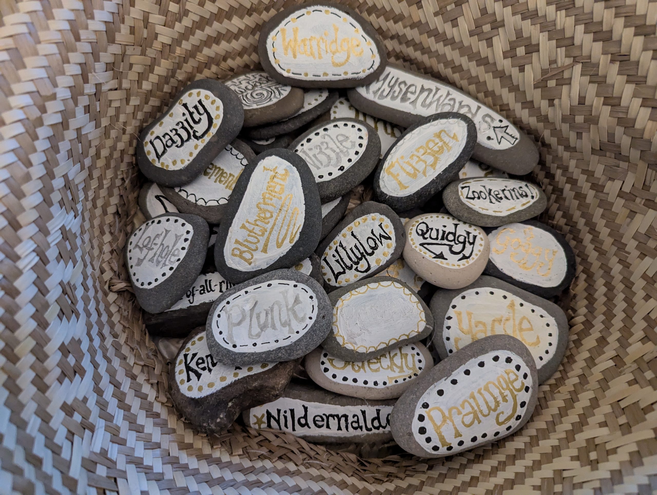 Image shows a basket of pebbles. each painted with an old Nidderdale or Yorkshire word